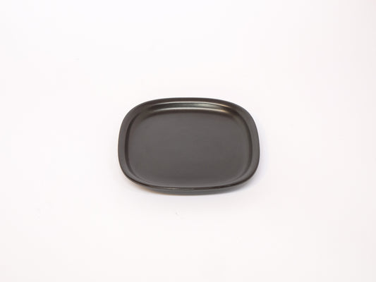 Small black and white ceramic plate from 柳宗理's modern dinnerware series, featuring clean, minimalist design.
