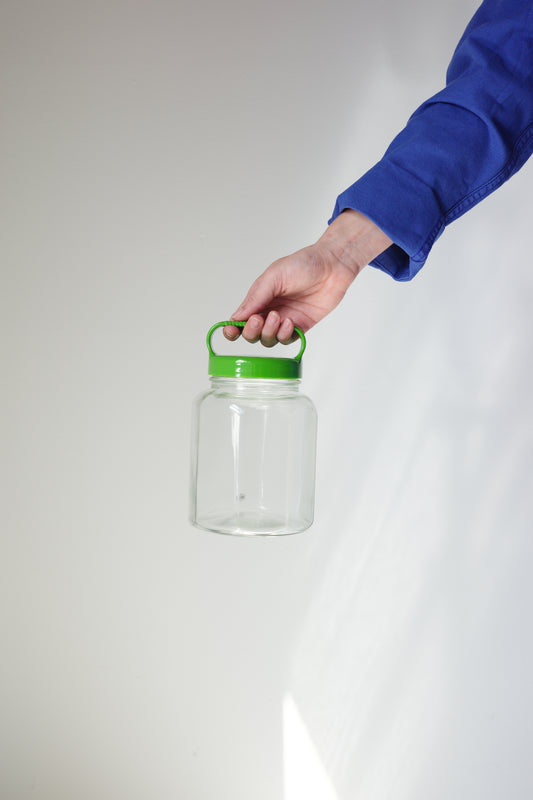 Handheld glass bottle by Okawa Glass with a simple design, ideal for storing liquids or decorative use.
