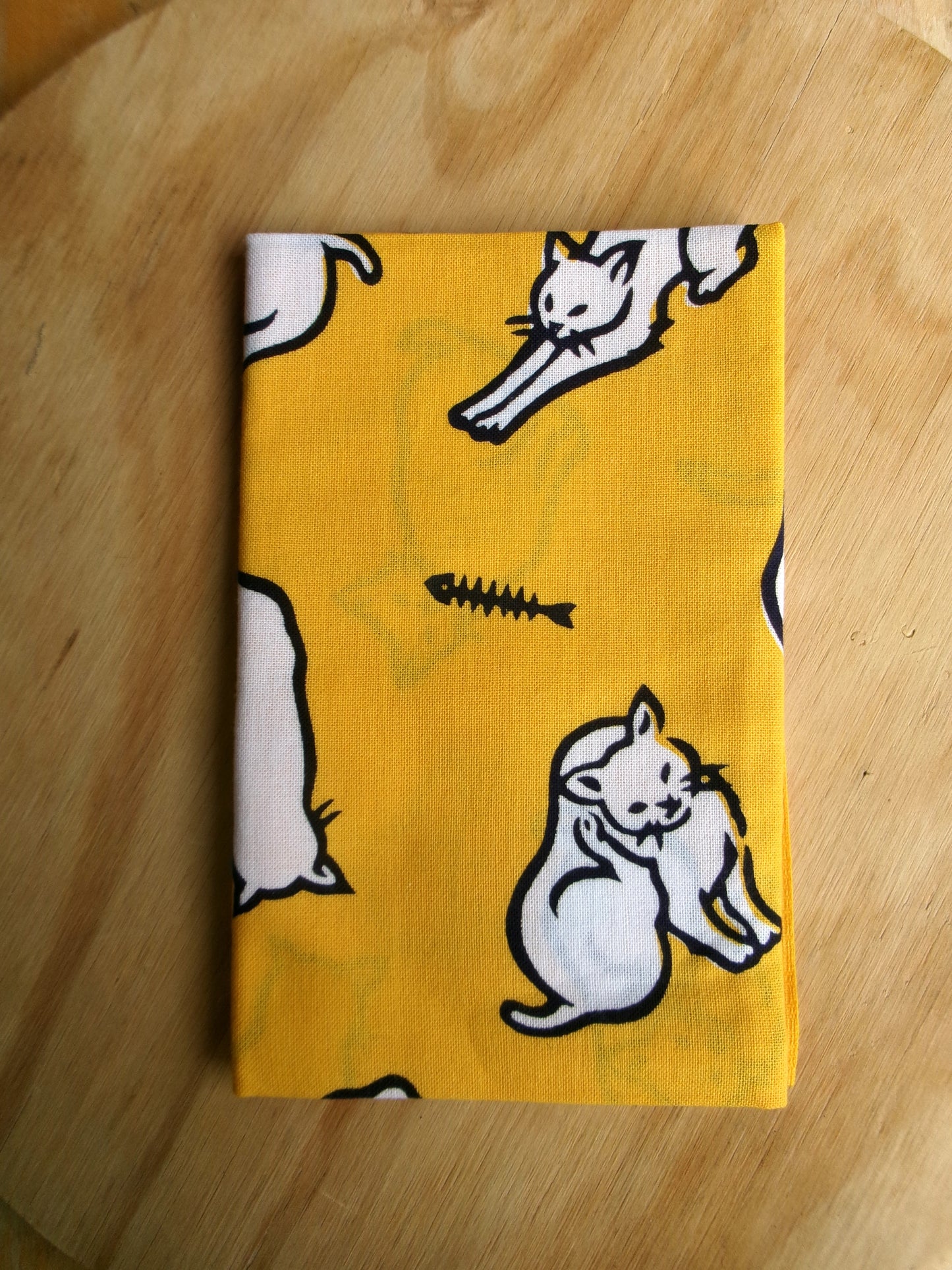 Cotton tenugui hand towel featuring cat-themed design by Kamawanu, showcasing colorful cat illustrations on white fabric.