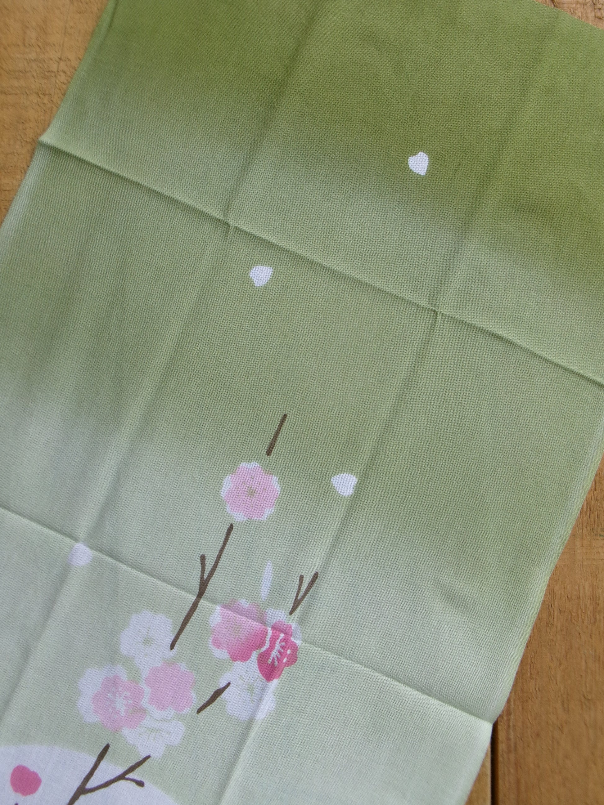 Japanese tenugui towel featuring sakura cherry blossom design by Kamawanu, with intricate traditional embroidery and vibrant colors.