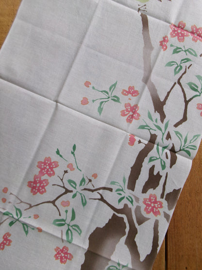 Japanese tenugui towel featuring cherry blossoms and a white-eye bird by Kamawanu, showcasing traditional floral design.