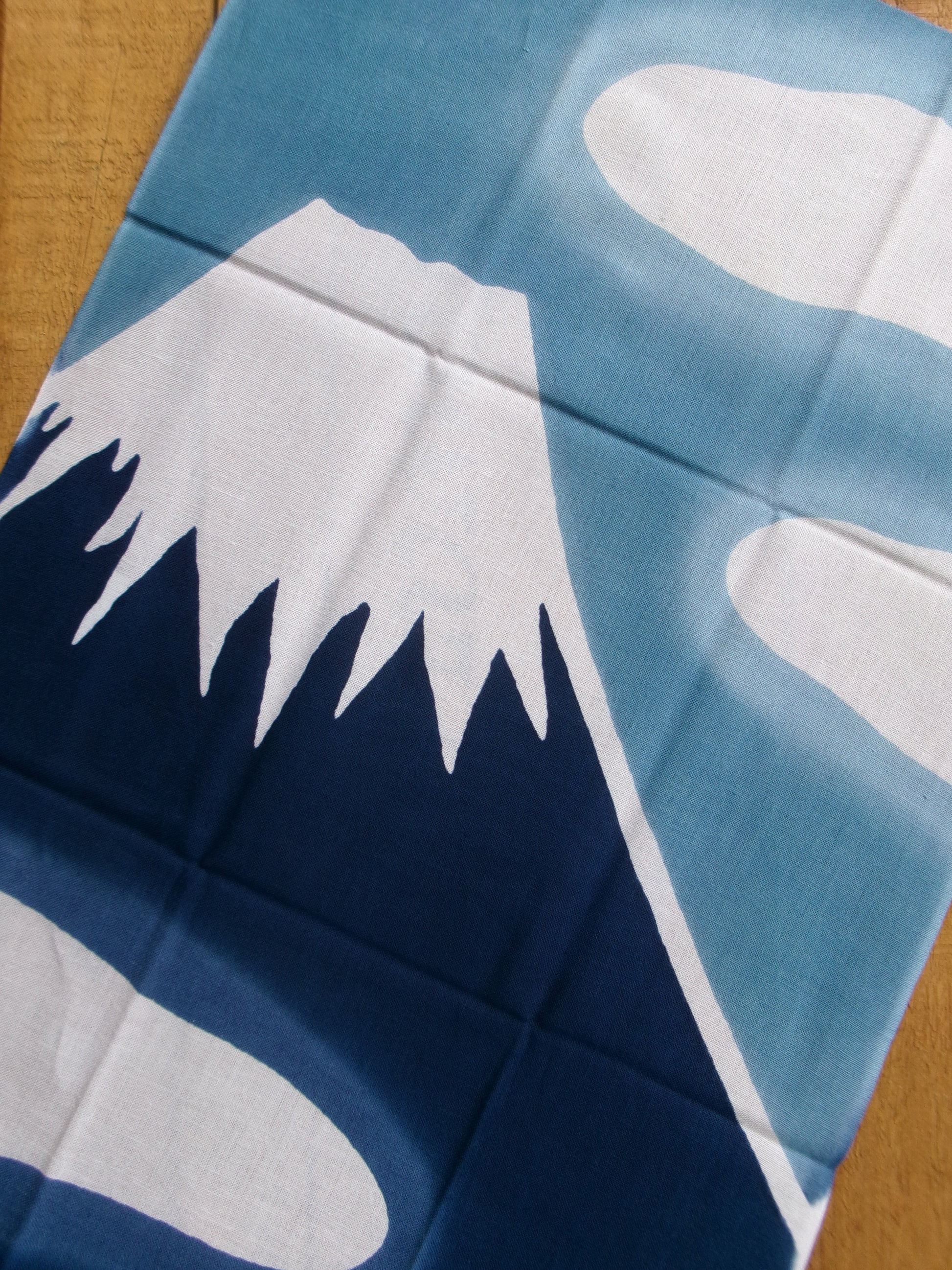 Japanese tenugui towel featuring Fuji Mountain and hot spring imagery, crafted by Kamawanu, showcasing traditional design and craftsmanship.