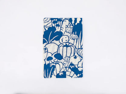 Japanese tenugui cloth featuring colorful vegetable illustrations by Kamawanu, showcasing a vibrant vegetable pattern on blue fabric.