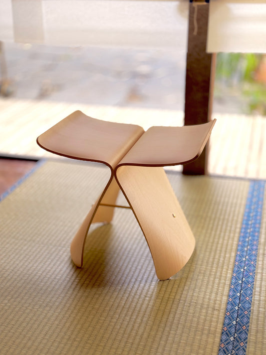 Sori Yanagi Butterfly Stool by CIBI Tokyo Store featuring a curved wooden seat and sleek design on a wooden floor.