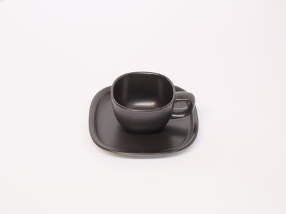 Black and white coffee cup with matching saucer by 柳宗理, sleek ceramic design, minimalist style for elegant coffee moments.