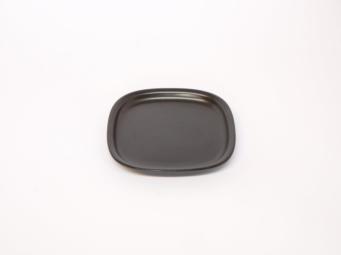 Small black and white ceramic plate from 柳宗理's modern dinnerware series, featuring clean, minimalist design.