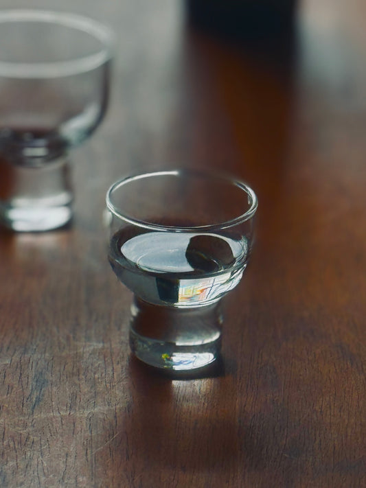 Sori Yanagi sake cup with elegant curved design, made of clear glass, showcasing traditional Japanese craftsmanship