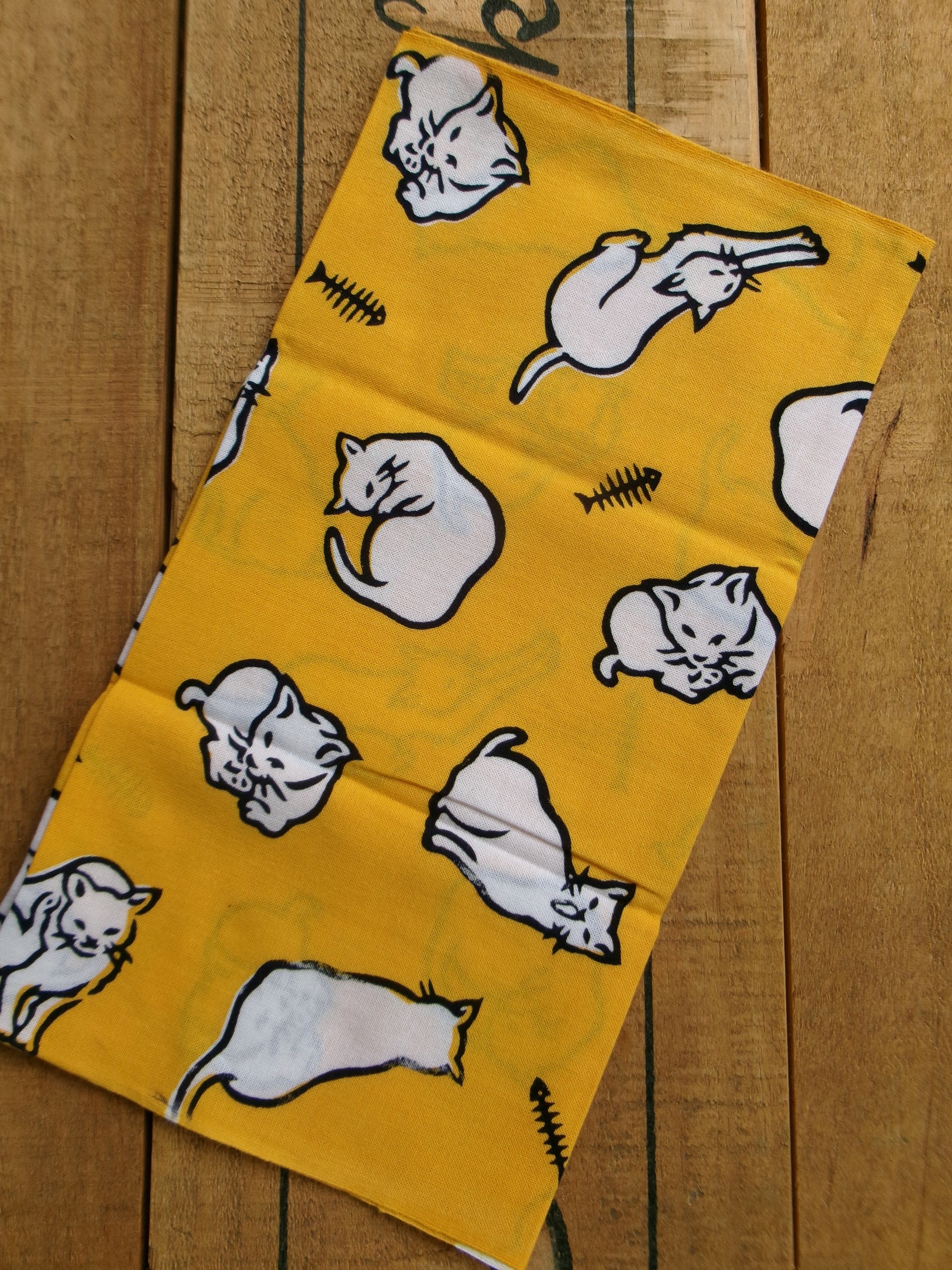 Japanese tenugui towel featuring playful cat patterns by Kamawanu, showcasing traditional fabric design with colorful feline motifs.