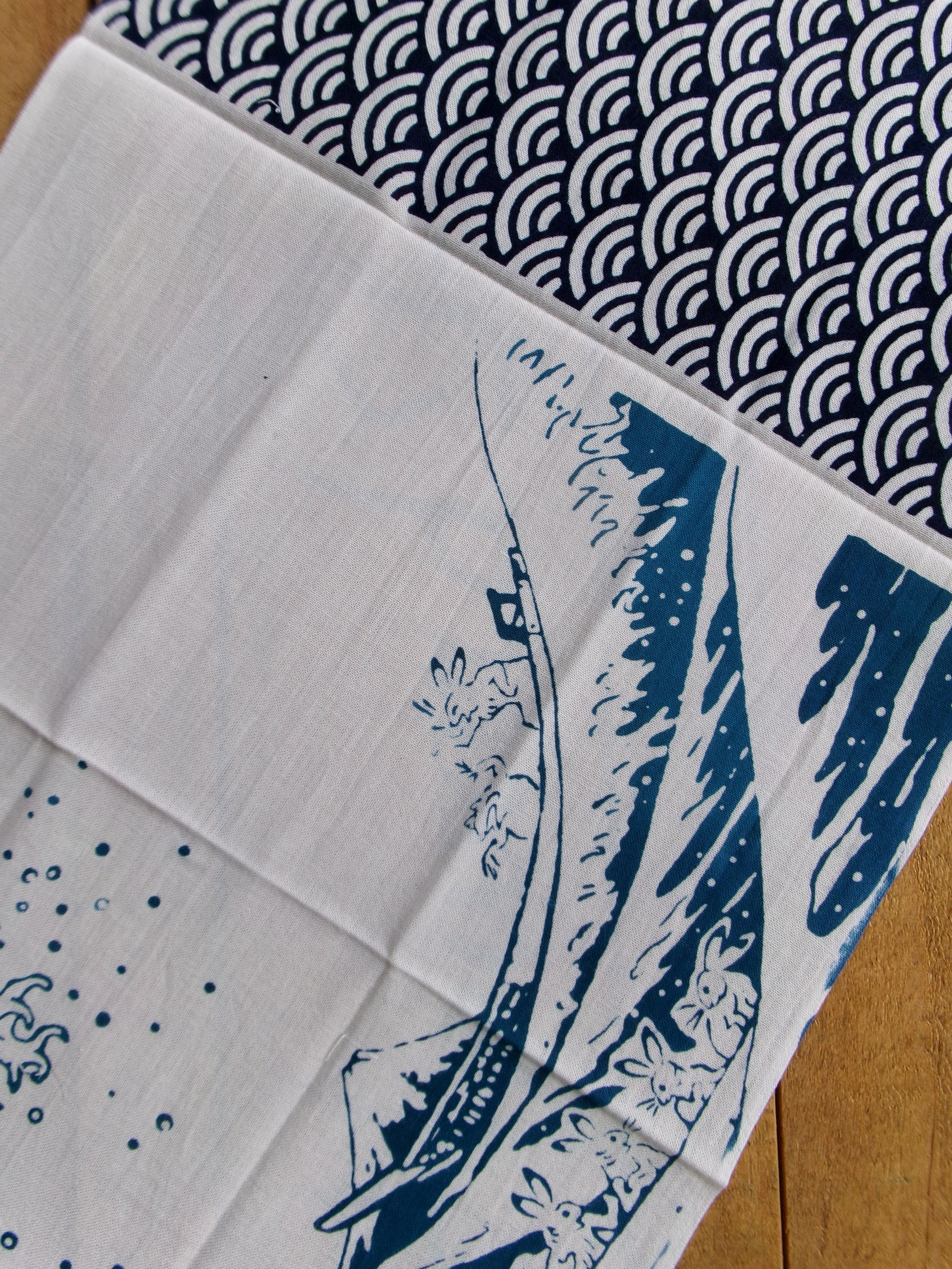 Traditional tenugui cloth featuring Chōjūjiga and The Great Wave off Kanagawa designs by Kamawanu, showcasing vibrant Japanese artwork.