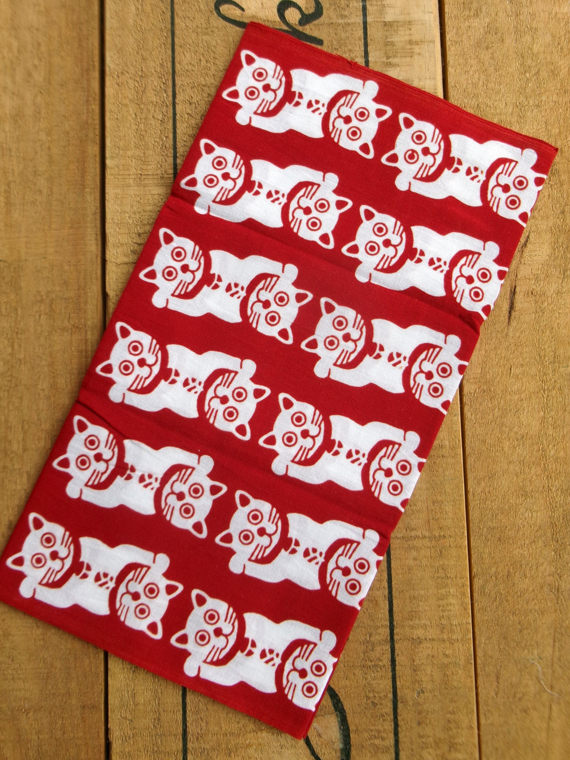 Japanese tenugui featuring lucky cat and traditional patterns by Kamawanu, showcasing intricate textile design and vibrant colors.