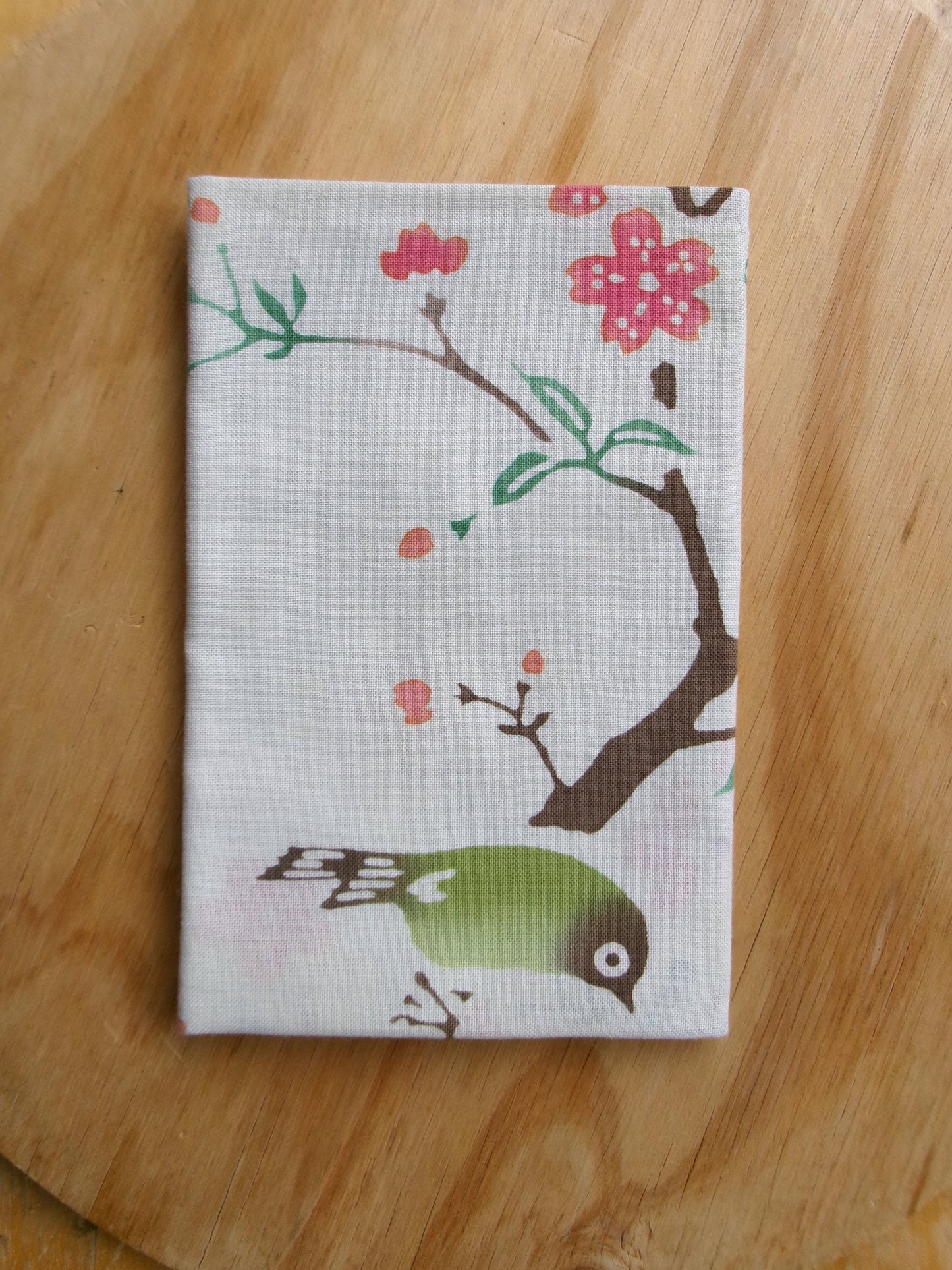 Cotton tenugui towel featuring cherry blossoms and a Japanese white-eye bird in traditional Japanese design by Kamawanu.